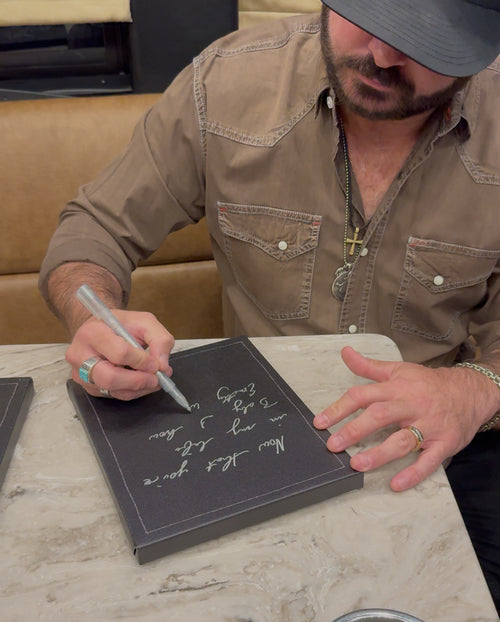 Man writing on a blackboard with a pen in a casual setting