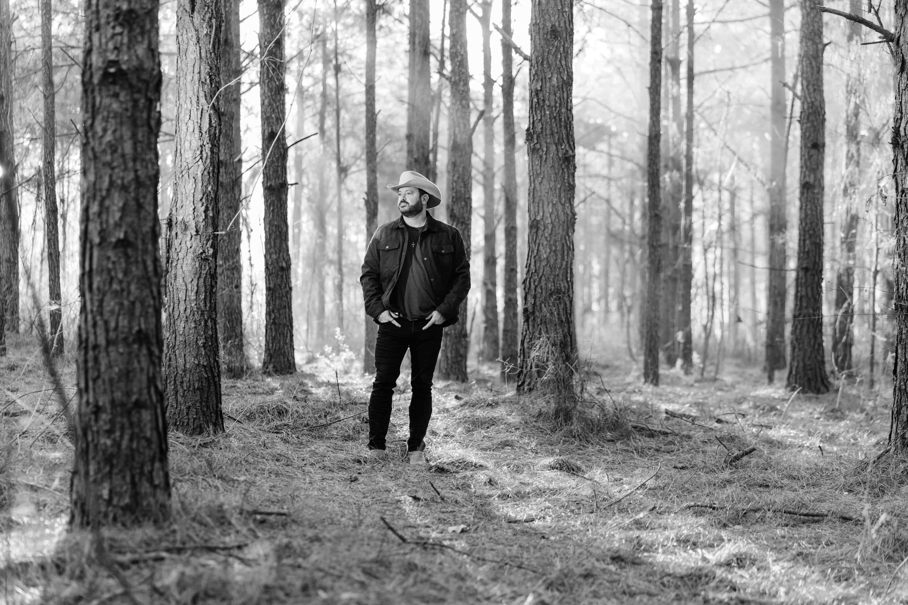 Black and white photo of Wade standing in a forest