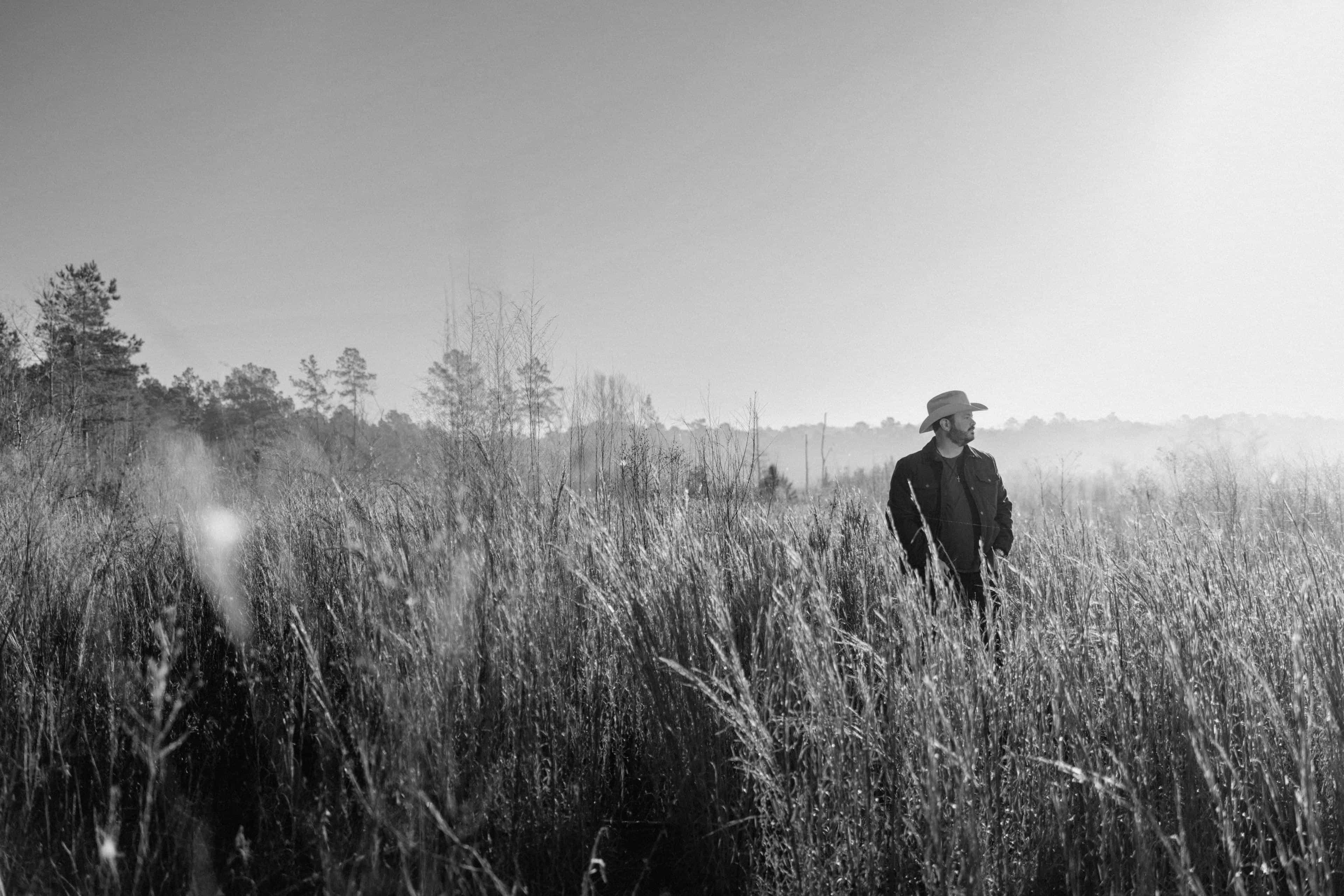 Black and white photo of Wade standing in a grassy field